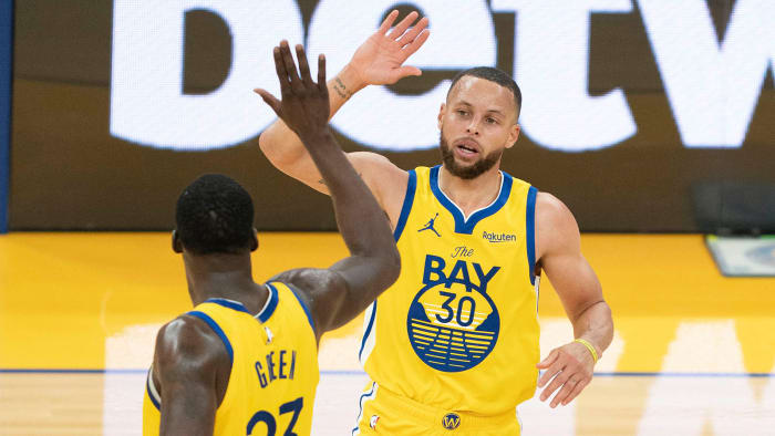 Golden State Warriors guard Stephen Curry celebrates with forward Draymond Green.